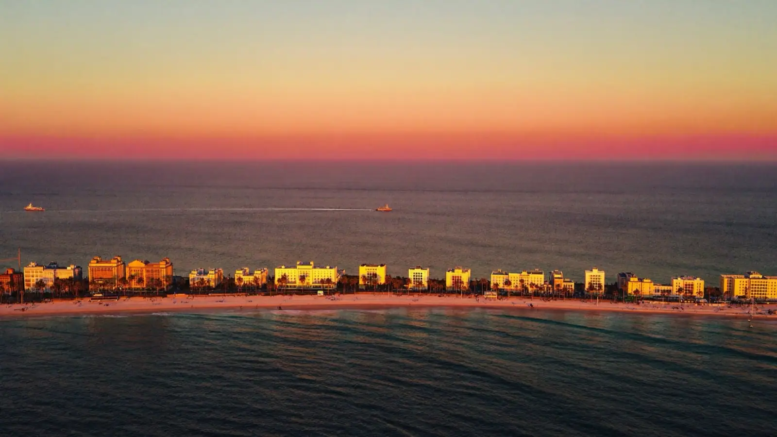 Aerial view of Miami Beach at golden hour — Atlantic ocean in deep blue, art deco buildings along Ocean Drive catching the warm last light
